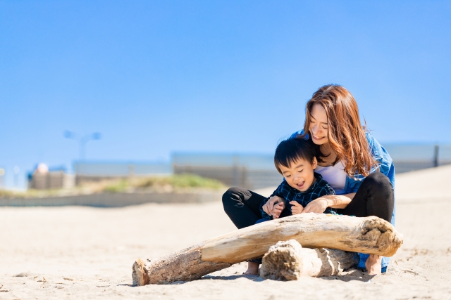 砂浜で遊ぶ母親と男の子